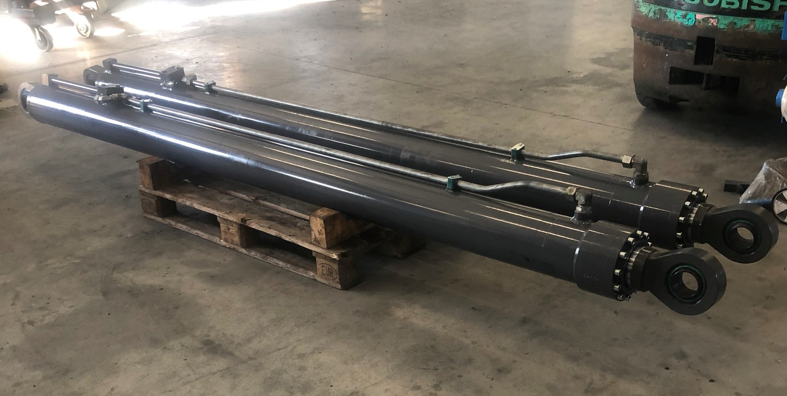 Zwei lange instandgesetzte Hydraulikzylinder in der Werkhalle
