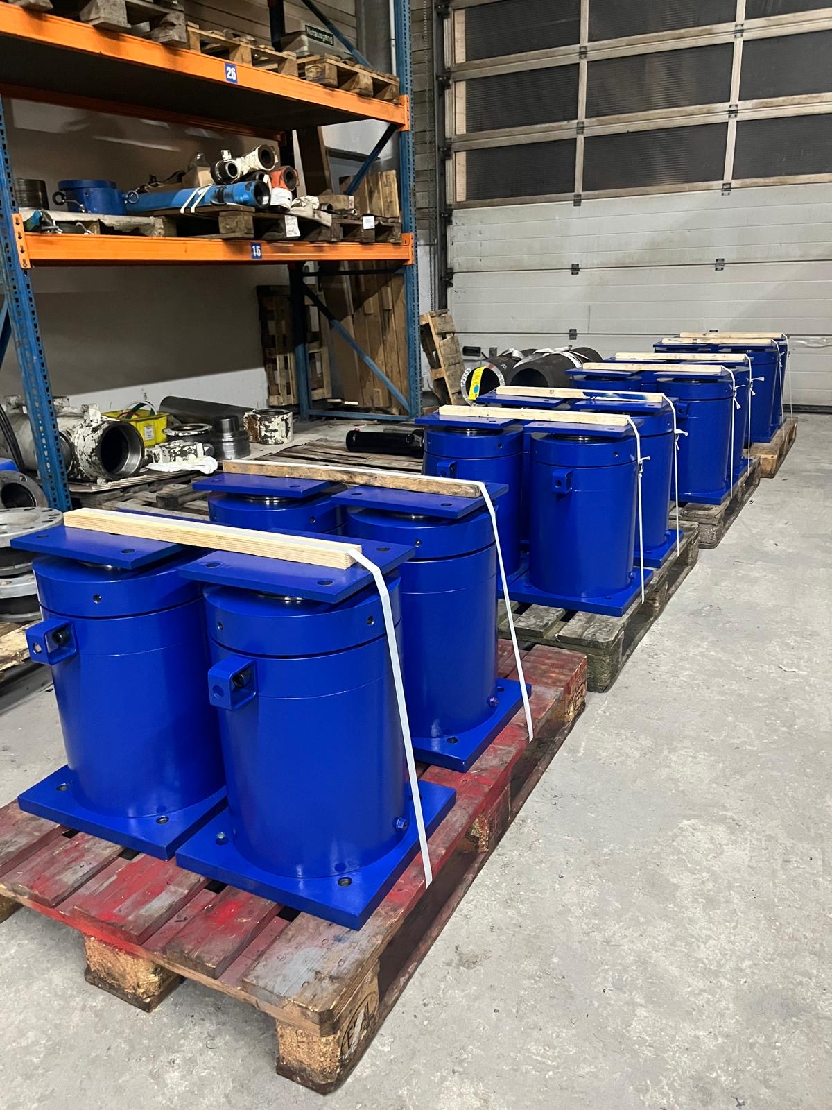 Reihen neu gefertigter blauer Hydraulikzylinder auf Paletten
